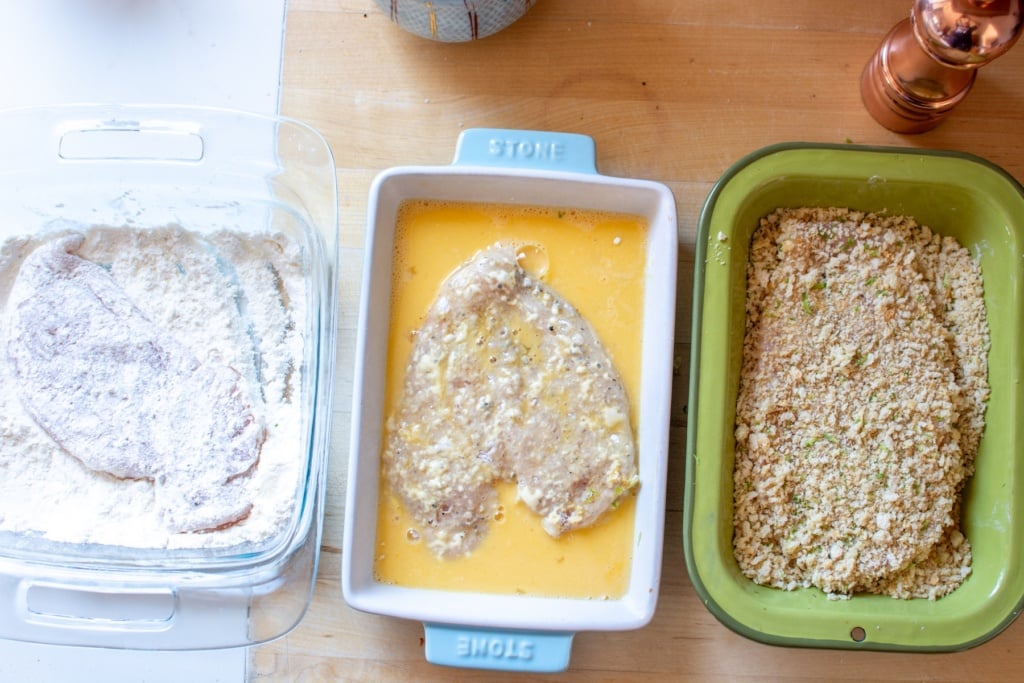 chicken breasts in each of the three dishes of breading