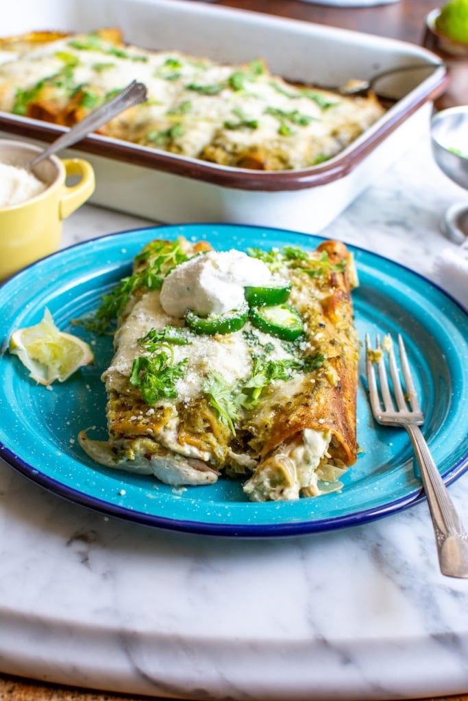 a serving of chicken enchiladas on a blue plate