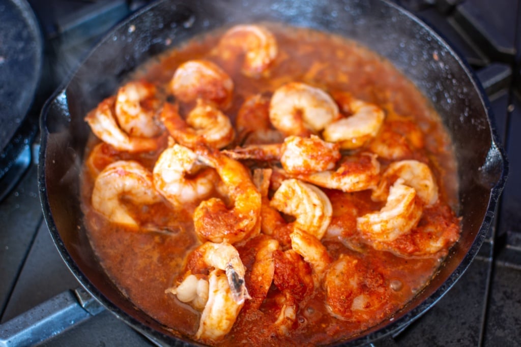 shrimp cooking in the sauce in a skillet