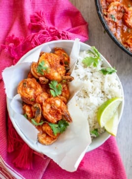 shrimp in a bowl with rice on a pink napkin