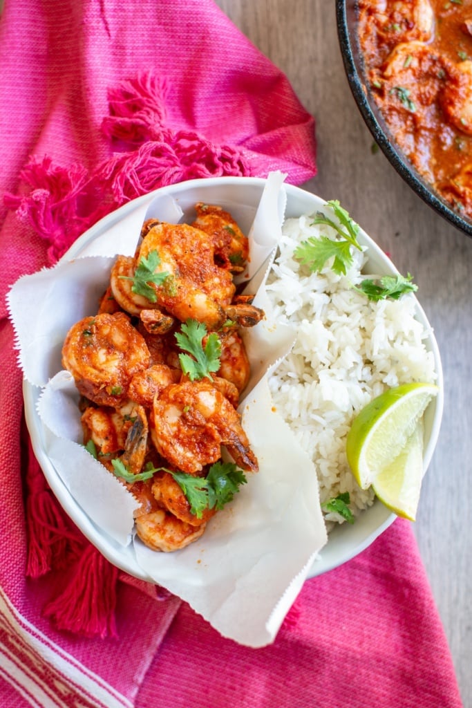 shrimp in a bowl with rice on a pink napkin