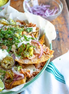 close up of shredded chicken nachos topped with jalapeno