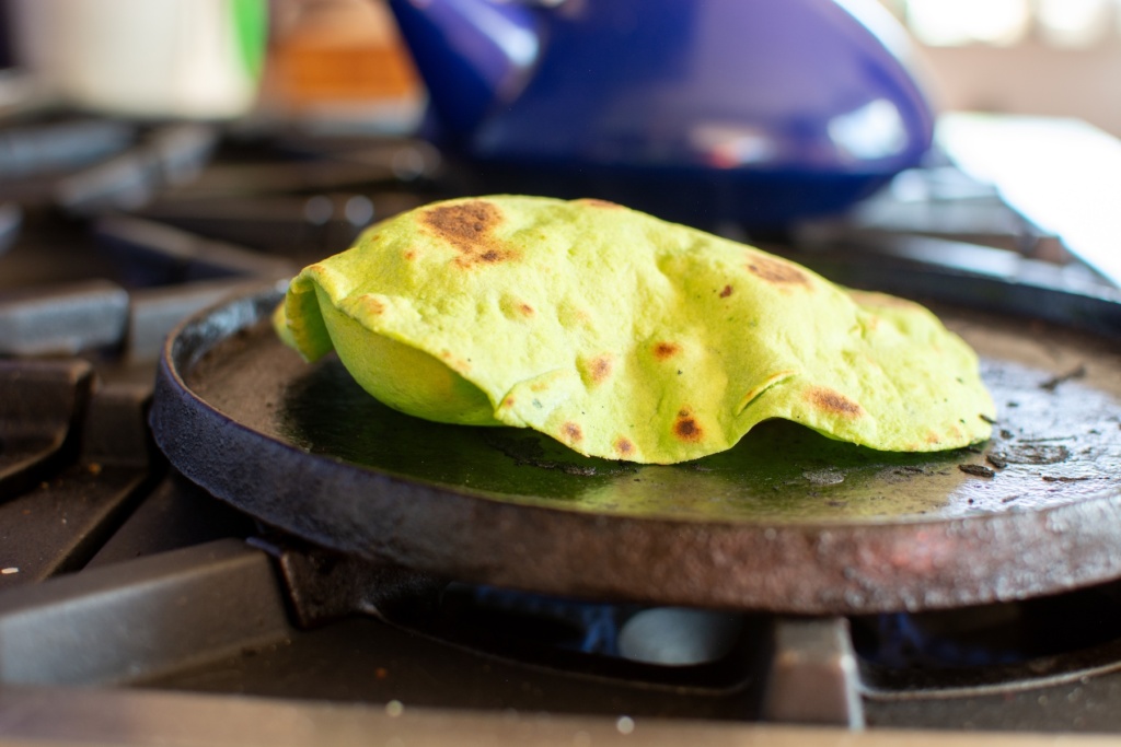 a spinach tortilla on a comal