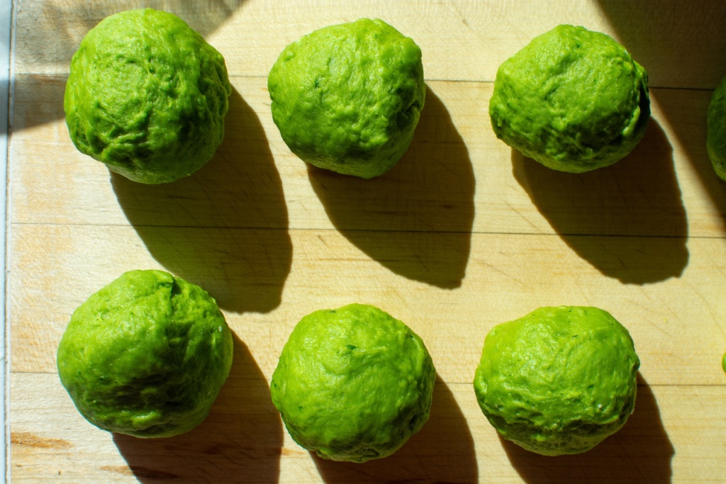 green dough balls on a wooden board