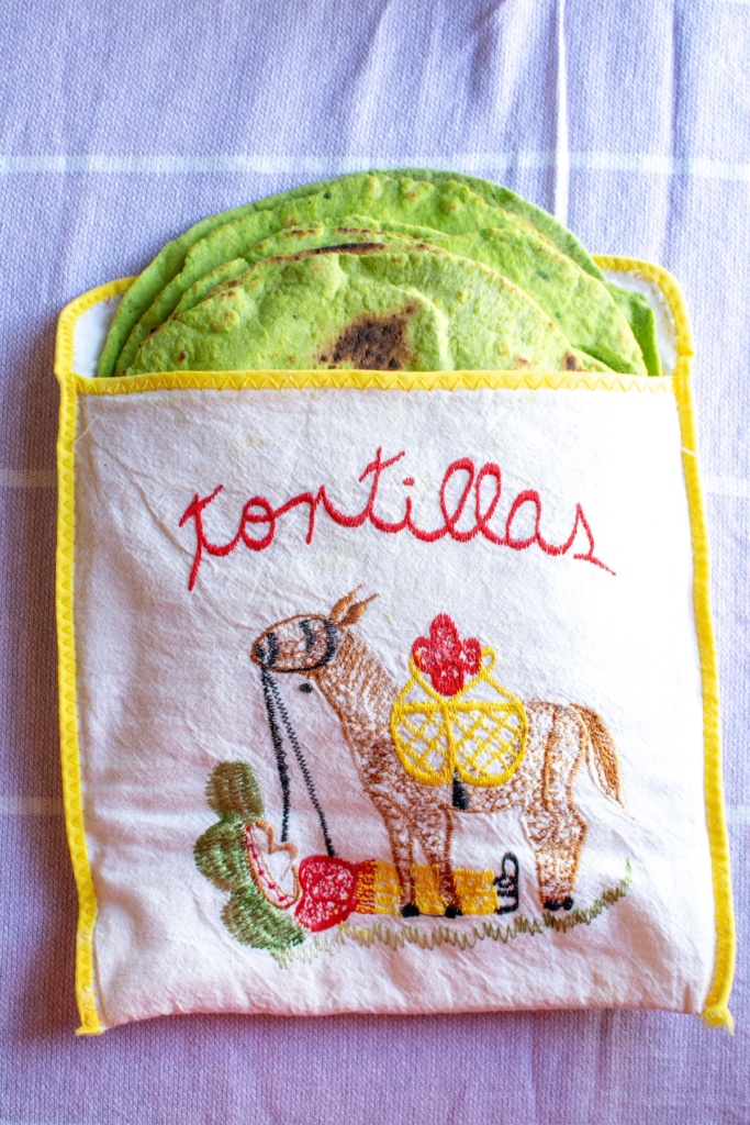 a stack of spinach tortillas in a warmer