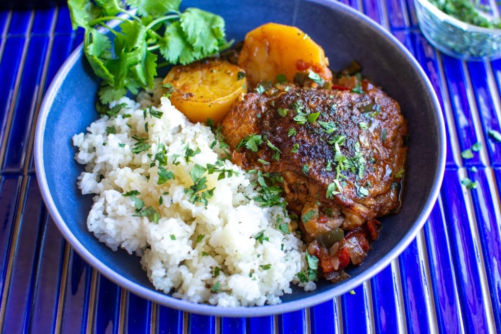 chicken and rice with potatoes in a blue plate