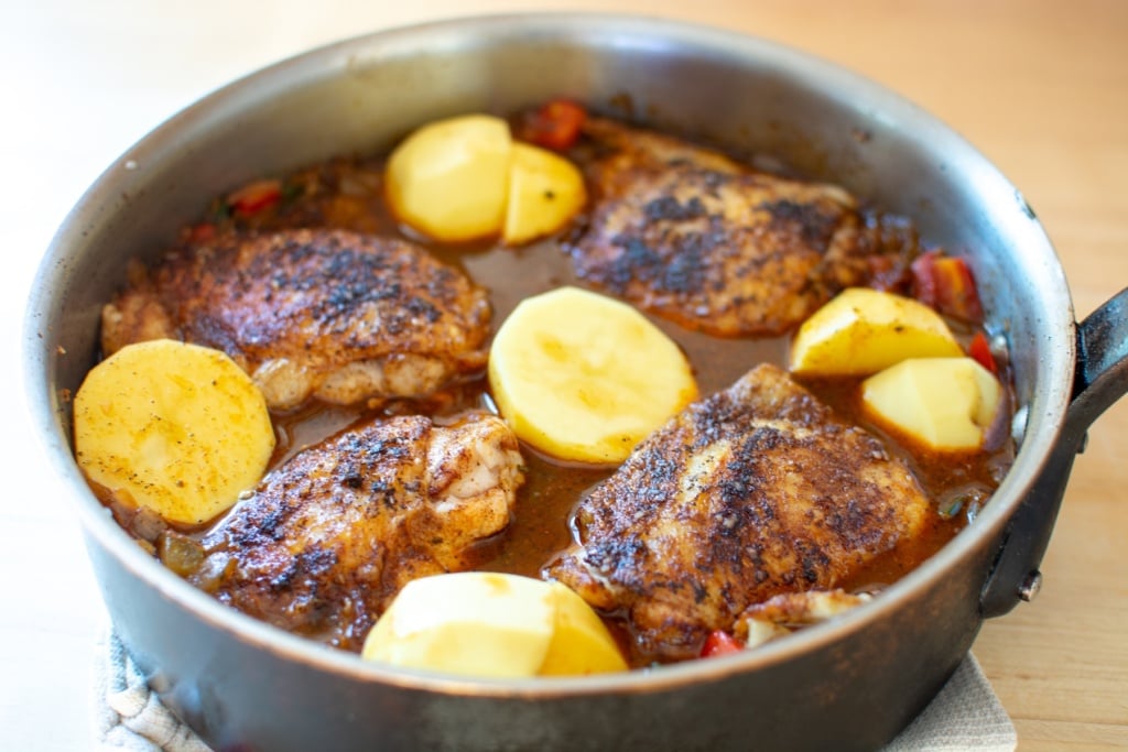 chicken in a skillet with potatoes