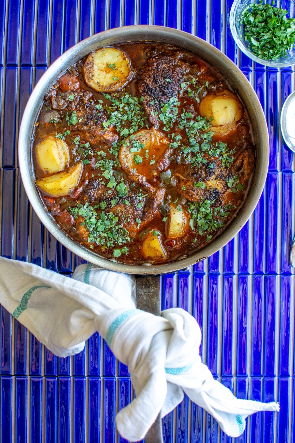 a pot of chicken guisado on blue tile